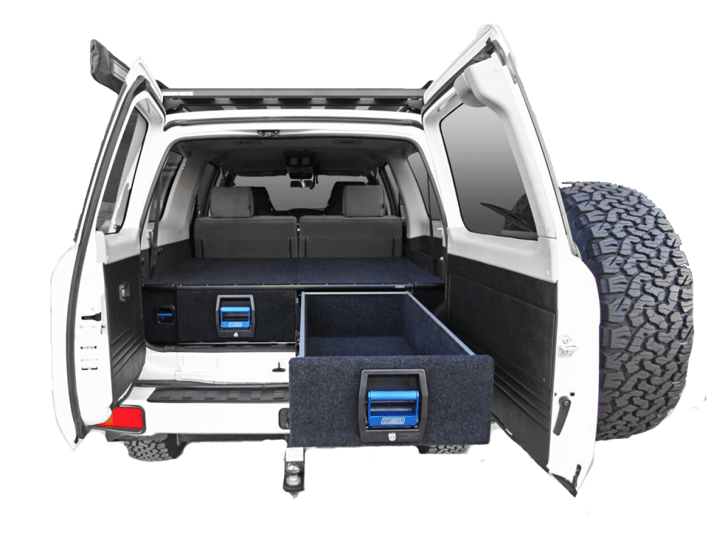 The back end of a white truck with its cargo drawer compartment open.