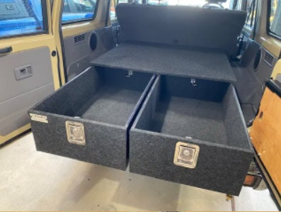 A van with two cargo drawers in the back.