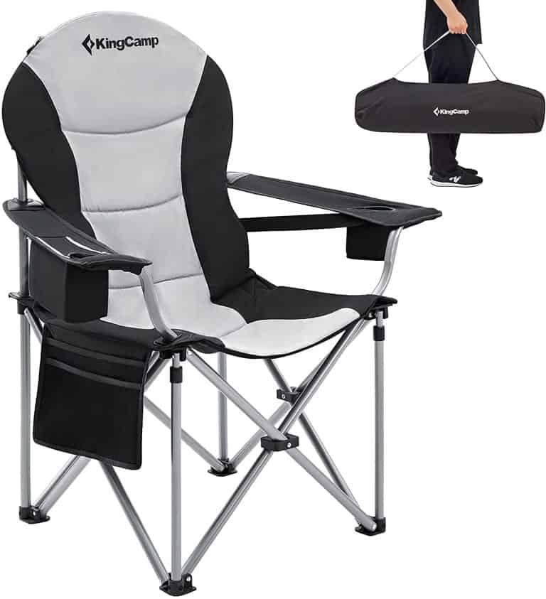 a man standing next to a folding chair.