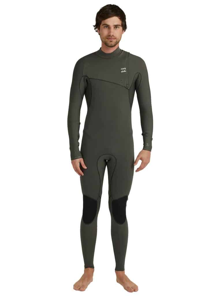 A man in a surfing wetsuit standing in front of a white background.