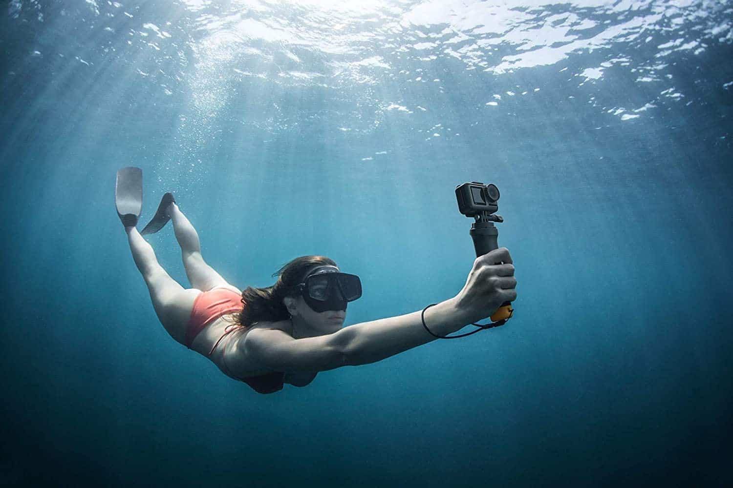 A woman in a bikini uses an underwater camera.