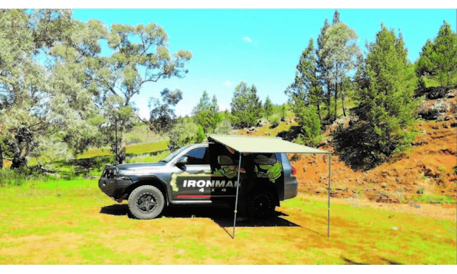 An SUV with an awning tent on the back.