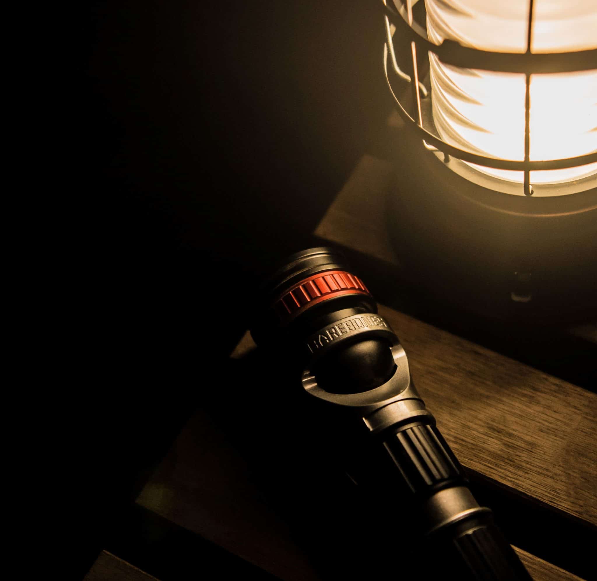 An essential camping accessory - a flashlight - rests on a wooden table.