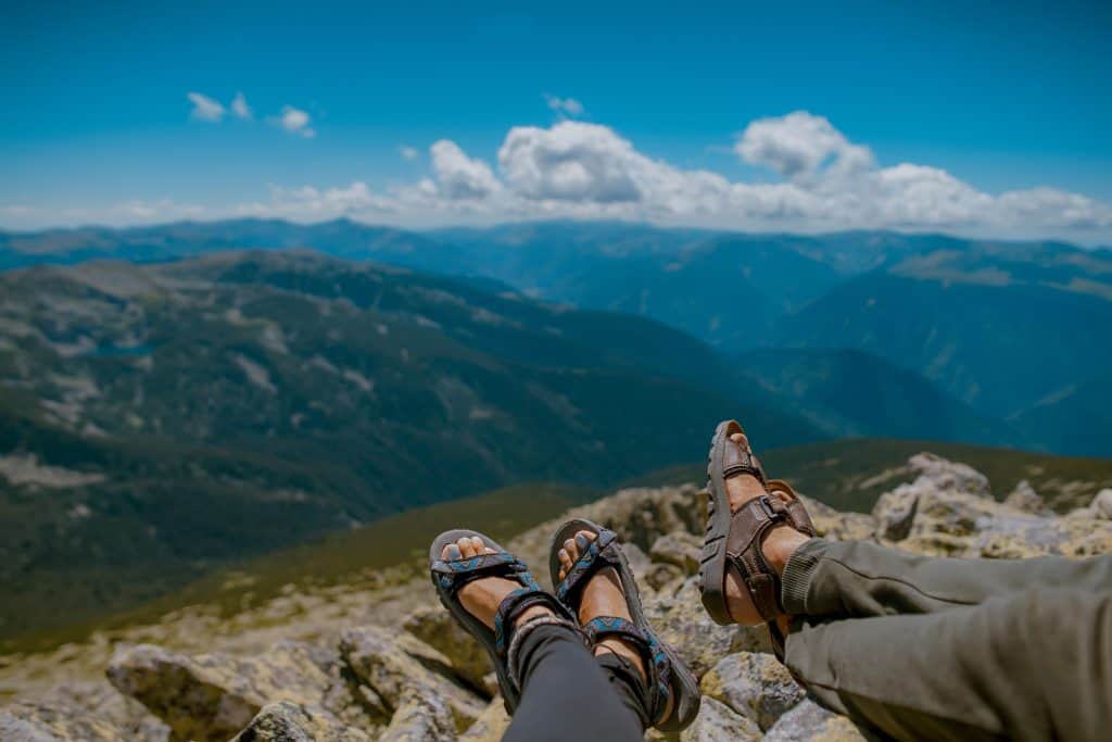 a person sitting on top of a mountain with their feet up.
