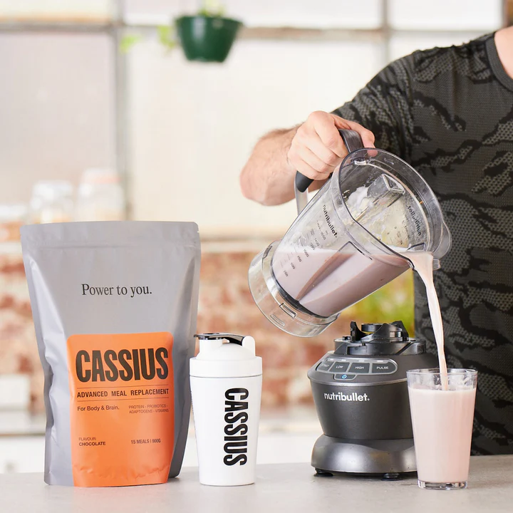 a man pouring a drink into a blender.