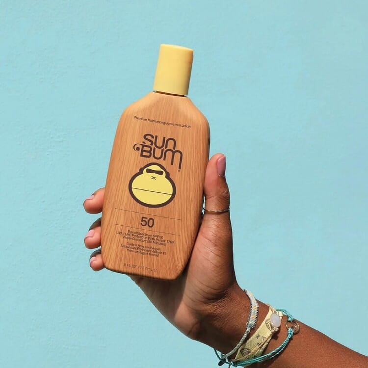 A bottle of Best sunscreen held by a hand for sun protection.