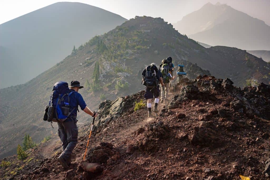 a group of hikers hiking up a mountain.