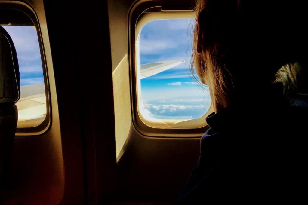 a woman looking out the window of an airplane.