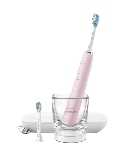 a pink electric toothbrush sitting in a glass.
